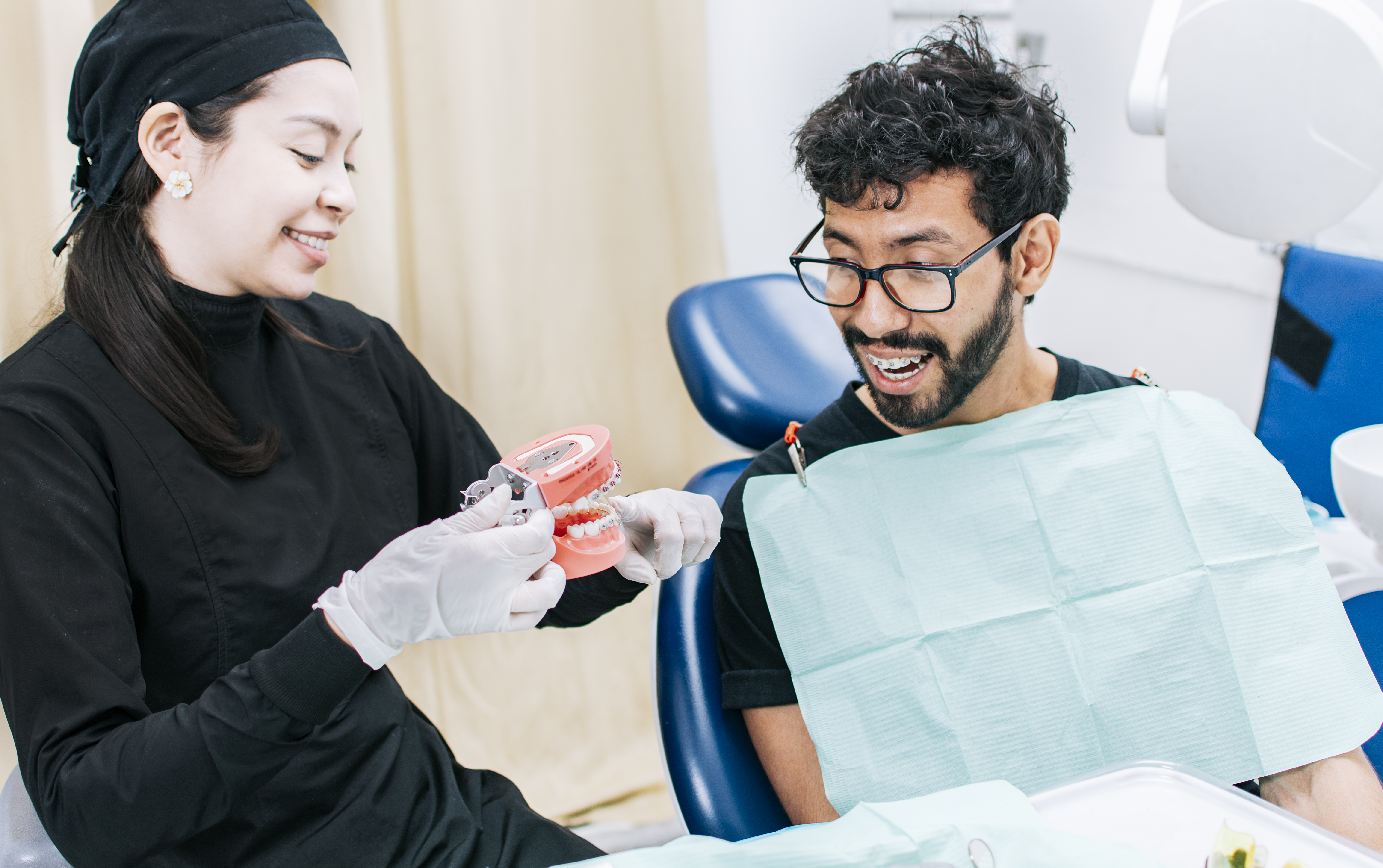 Dentist with patient showing a denture dentist pointing out a denture to a patient dentist explaining dental hygiene to a…
